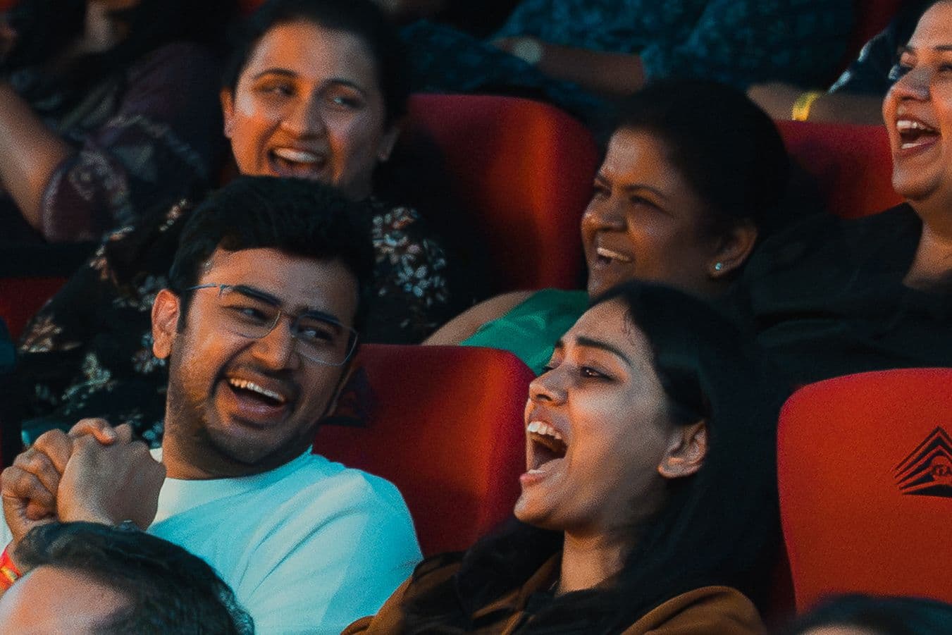 Audience members laughing in the theatre